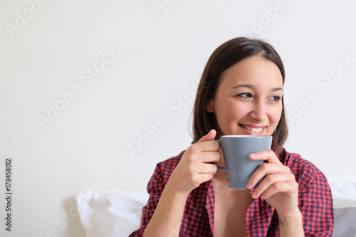 Plakat Kobieta relaksująca i szukająca coziness pije od filiżanki