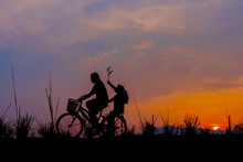 Silhouette Of A Girl Riding On A Trail With His Bike.