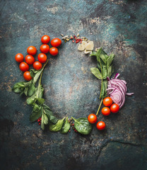 Round frame with vegetarian cooking ingredients on dark rustic background, place for text, frame. Healthy eating and cooking, clean or diet food concept