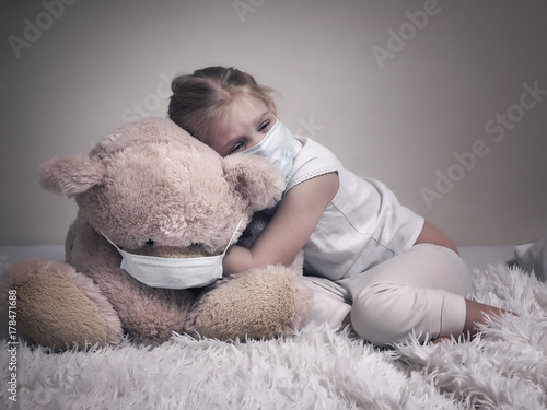 Fotografie, Obraz Little girl and big plush bear in medical masks