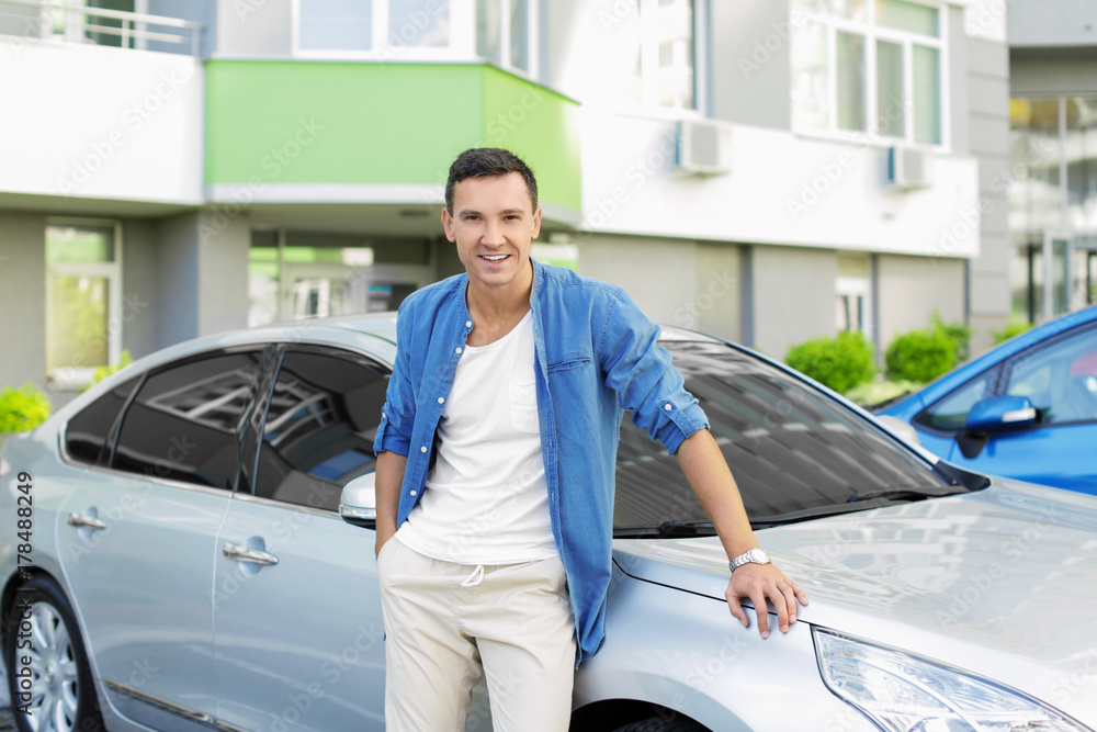 Man in casual clothes standing near car