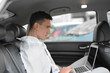 © Africa Studio - Businessman using laptop in car