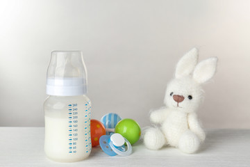 Composition with feeding bottle of baby milk formula on wooden table