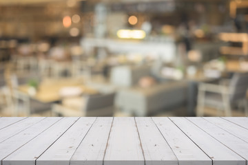 Empty white wood table top on blurred background at coffee shop,copyspace for montage your products