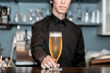 © BSD - ビールを差し出すバーテンダー
