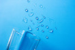 canvas print picture - Drops of pure water spilled from a glass on a blue background
