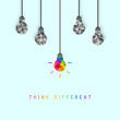 Think different concept with creative and colorful lightbulb being more unique than the surrounding grey ones