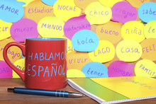 Study Spanish Concept, A Mug With Written Words Speak Spanish, Notebook, Pen And Notes With Common Spanish Words.