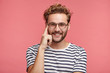 © wayhome.studio  - Cheerful bearded young guy with confident expression keeps finger on temple, has gentle smile, rejoice good pleasant compliment from beautiful girl, isolated over pink background. Joy concept