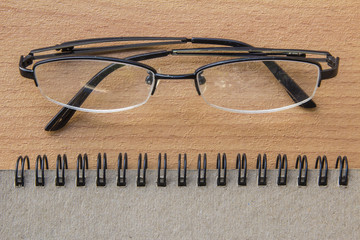 Notebook with glasses on the desk.