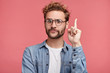 That is! Handsome clever student wonk or geek wears round glasses, raises finger as understands new theory, going to prove it, looks confidently, isolated over pink background. Confidence concept