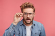 © WHstudio Leushin N - Puzzled emotional male with surprised expression looks through spectacles, tries to make out something into distance, has bad eyesight, sees terrified things. People and facial expressions concept