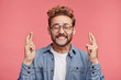 © wayhome.studio  - Glad positive bearded man crosses fingers, closes eyes with pleasure, anticipate hearing good news, isolated pink background. Happy male rejoices that his dreams came true. Excitement concept