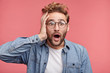 © WHstudio Leushin N - Shocked bearded man with jaw dopped out and bugged eyes, stares at camera as sees awful car accident, being horrified and in stupor. Amazed stressful male adult poses over pink wall indoors.