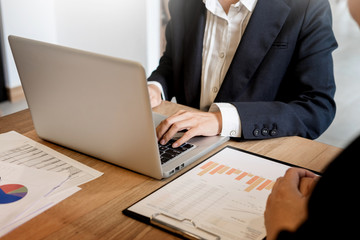 Businessman team working at office desk and using a digital computer laptop hands detail, computer and objects on the table.