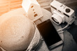 © whyframeshot - Camera vintage with woman hat and smartphone on pool side terrace in concept holiday.