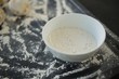 Close up of flour in bowl by dough n baking sheet