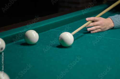 Zdjęcie XXL stół bilardowy zielony w hali z białymi kulkami z ręki człowieka