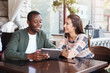 © Prostock-studio - Young couple using digital tablet in cafe