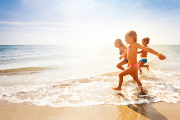 Wall Mural - cute kids having fun on sandy beach in summer