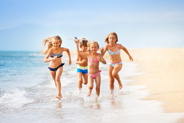 Wall Mural - Happy kids playing with toy plane by the sea