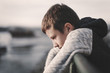 © sakkmesterke - Sad little boy leaning over railing