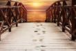 wooden walkways, pier, covered with snow, lead to the river at sunset