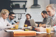 © leonidkos - University students work together on a new project. Business meeting and discussion plan. Team work at table with electronic devices and gadgets