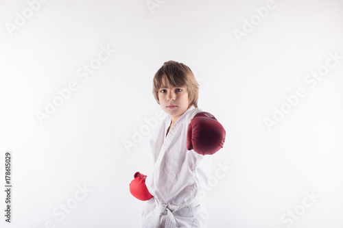 Zdjęcie XXL Portret jest ubranym kimonowe, czerwone bokserskie rękawiczki i pozować karate dzieciak