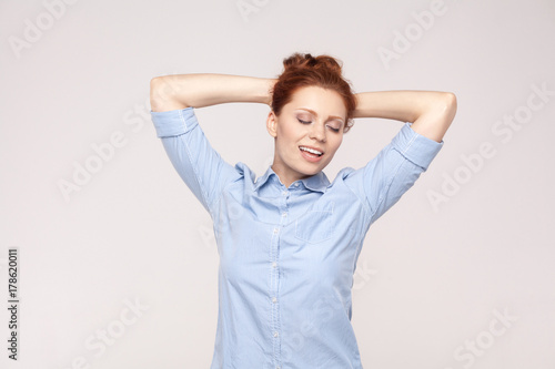 Zdjęcie XXL Koncepcja relaksacji. Szczęście i piękna imbirowa dama, trzymająca dłoń przy głowie, relaksująca i zamknięta.