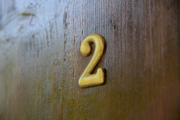 Old vintage aged scratched number 2 two letter on the old door