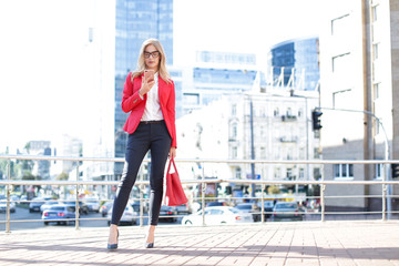 Canvas Print - Young businesswoman with mobile phone outdoors