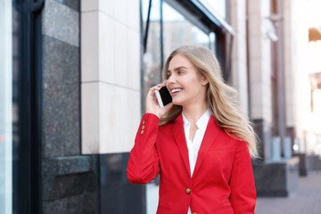 Canvas Print - Young businesswoman talking on mobile phone outdoors