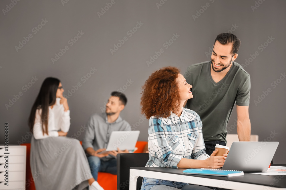 Young professionals working at table in office