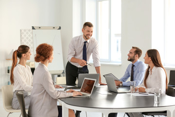 Canvas Print - Team of young professionals conducting business meeting in office