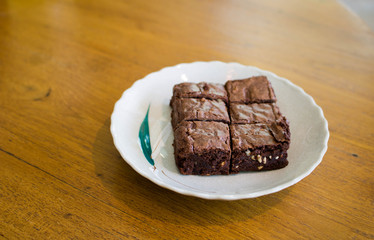 chocolate brownies or chocolate cakes with nuts on white plate