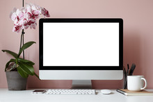 Mock Up Of Creative Desktop Of Female Designer With Nobody Around: Modern Electronic Gadgets, Mouse, Stationery Accessories, Notebook, Cup And Decorative Plant Against Blank Pink Wall Background