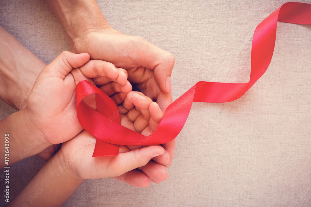 adult and child hands holding red ribbon, hiv awareness concept, world AIDS day, world cancer day - obrazy, fototapety, plakaty 