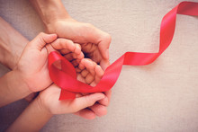 Adult And Child Hands Holding Red Ribbon, Hiv Awareness Concept, World AIDS Day, World Cancer Day