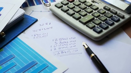 Poster - Camera flying over the office desk with financial documents and calculator.