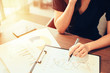 © vacancylizm - Business woman working at office with laptop and documents,rear view of young business woman hands busy using holding documents,Open space loft office reading sitting at the desk on office.