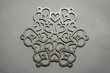 Silver snowflake ornament on silver background. Laser cut christmas decoration wood snowflake on silver painted background.