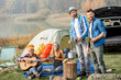 © rh2010 - Multi ethnic group of friends dressed casually having a picnic, cooking soup with cauldron, playing guitar during the outdoor recreation near the lake