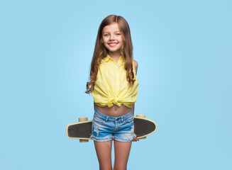 cheerful girl with longboard on blue