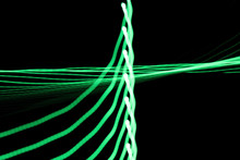 Green Neon Light Lines And Curves Abstract Image On Black Background Due To Camera Shake And Long Exposure Time