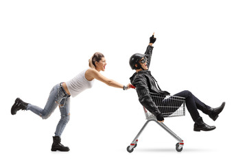 Wall Mural - Punk girl pushing a shopping cart with a biker riding inside and pointing up