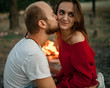 © Stanislav - Enamored couple sits and kisses on picnic in forest on bonfire flame background.
