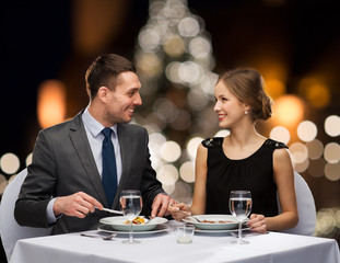 Canvas Print - smiling couple eating at christmas restaurant