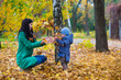 © Svetlana - Mother with little son play and smiles in park on background of colorful autumn fallen leaves