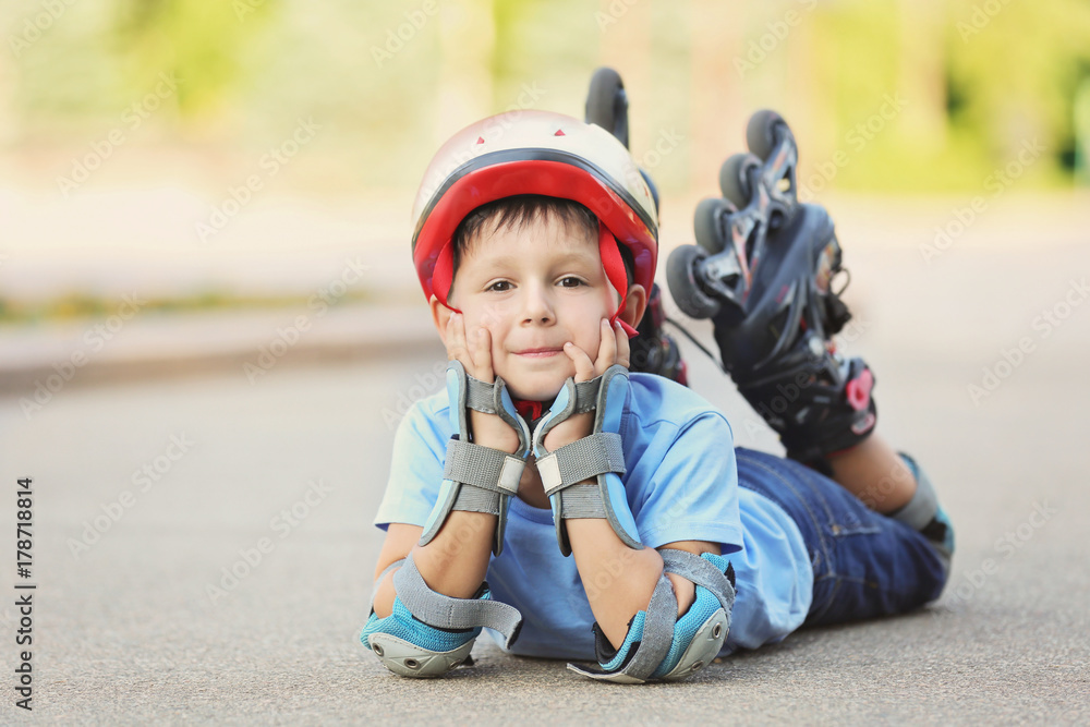 Little boy on roller skates in summer park